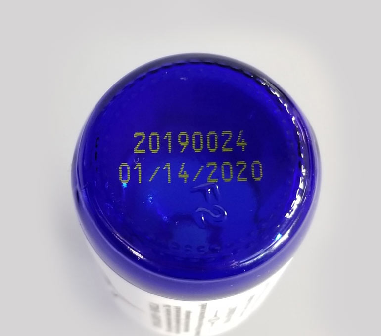 blue tincture bottle with yellow ink imprint of date and serial