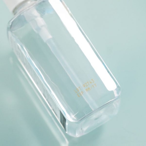 clear plastic pump bottle with yellow ink imprint of lot and expiration date