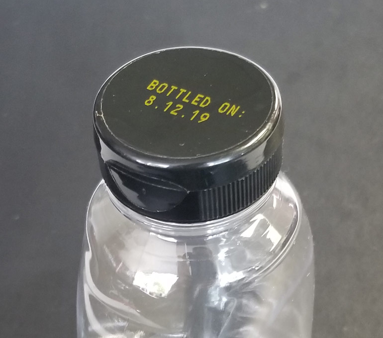 Empty honey squeeze bottle with bottle date in yellow ink