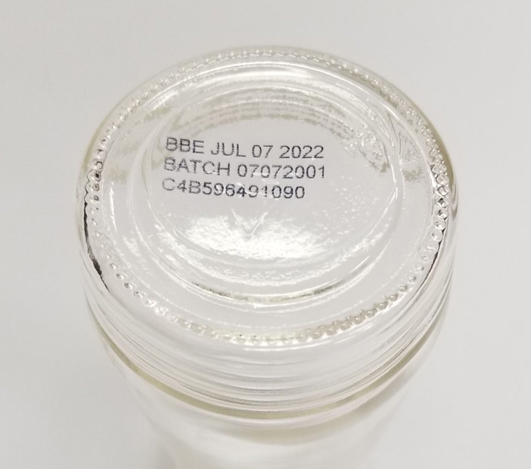 glass jar bottom with best by date, batch number, and serial